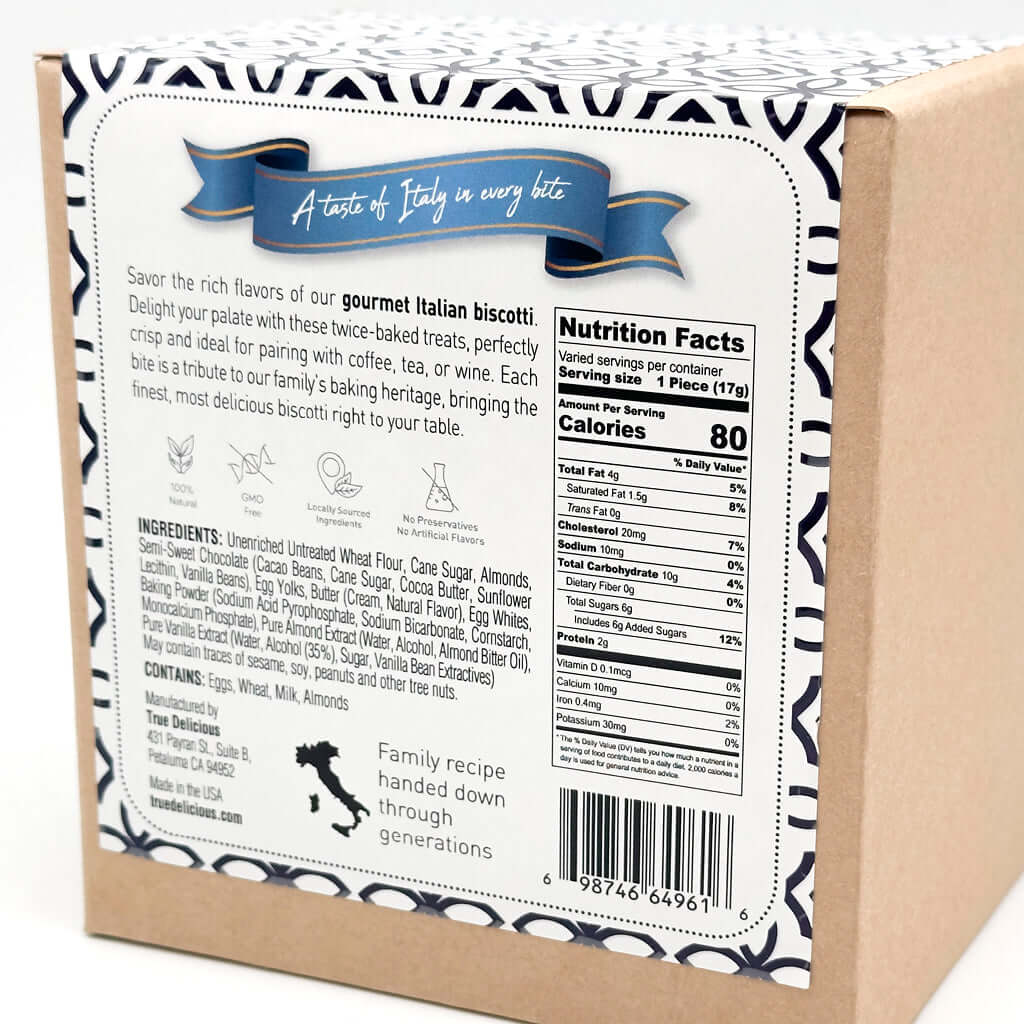 The back of the True Delicious 2x Chocolate Dipped Almond Biscotti box features product info, nutrition facts, ingredients, a barcode, and a blue ribbon stating A taste of Italy in every bite. It spotlights family recipe heritage and artisanal chocolate craft.