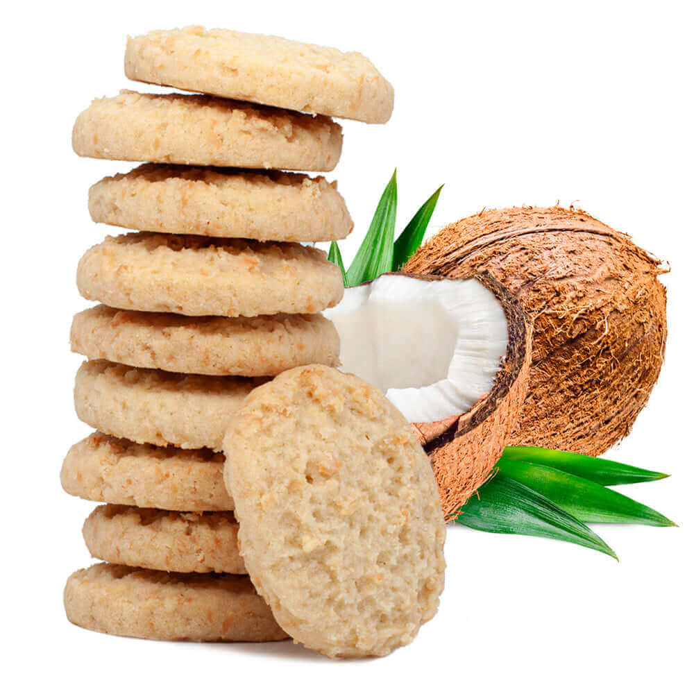 A stack of True Delicious Biscotti Coconut Shortbread Cookies is displayed before a halved coconut and green leaves, emphasizing the use of European-style butter on a white background.