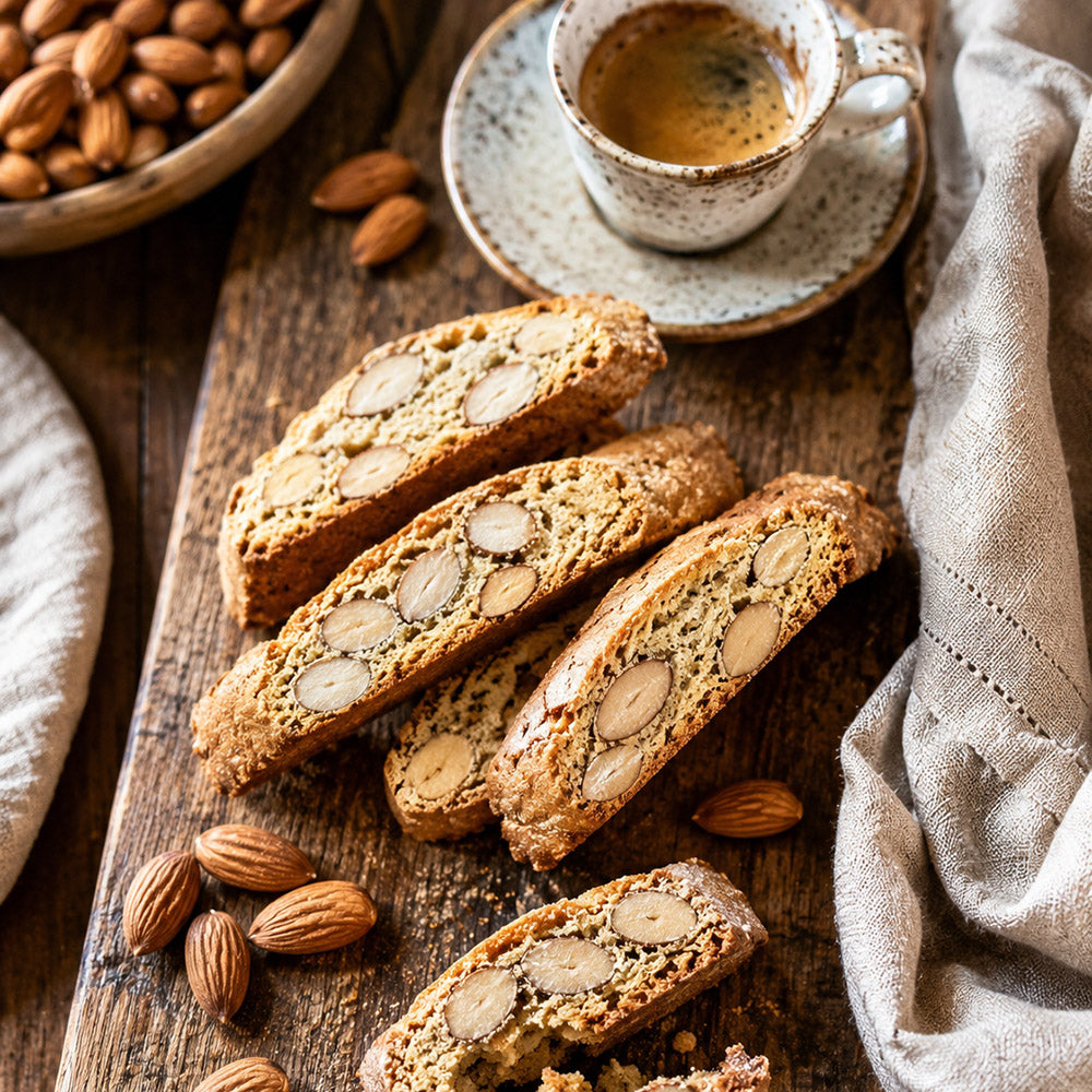 Authentic Italian almond biscotti being dipped into a steaming espresso cup — the traditional Italian morning ritual