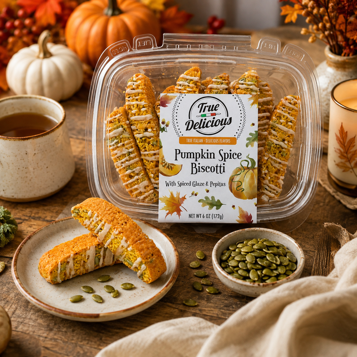 A jar of True Delicious Pumpkin Spice Biscotti with Glaze &amp; Pepitas sits atop a wooden table, accompanied by tea, a bowl of pepitas, a biscotti-filled plate, and autumn decor such as pumpkins and colorful leaves. Each piece is made from natural ingredients to highlight the comforting flavors of fall.
